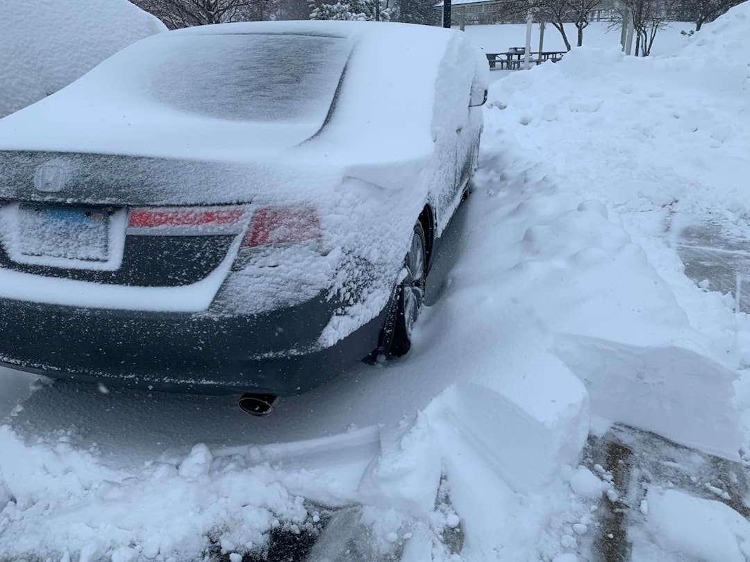 Car completely covered in snow after Chicago blizzard demonstrating winter preparation needs