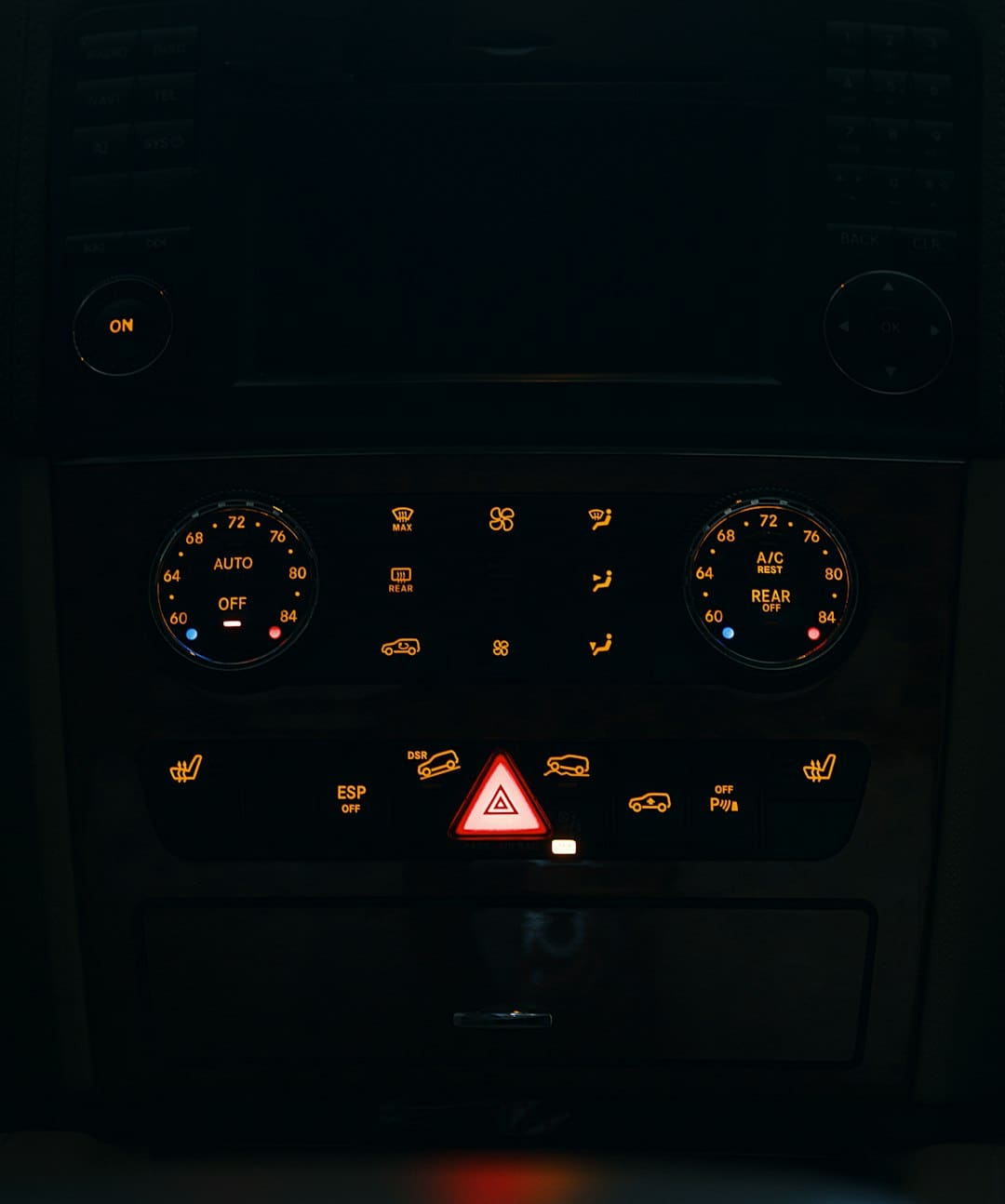 Car dashboard illuminated at night showing warning lights